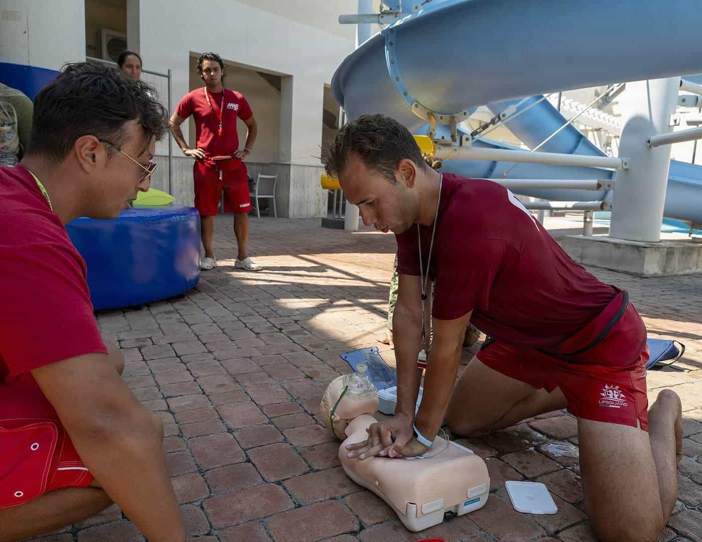 Trainees practising CPR on a manikin during a first aid drill