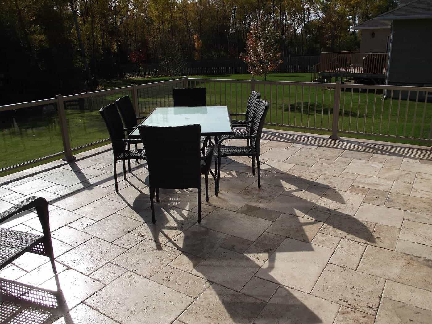 A travertine paved deck around an outdoor area